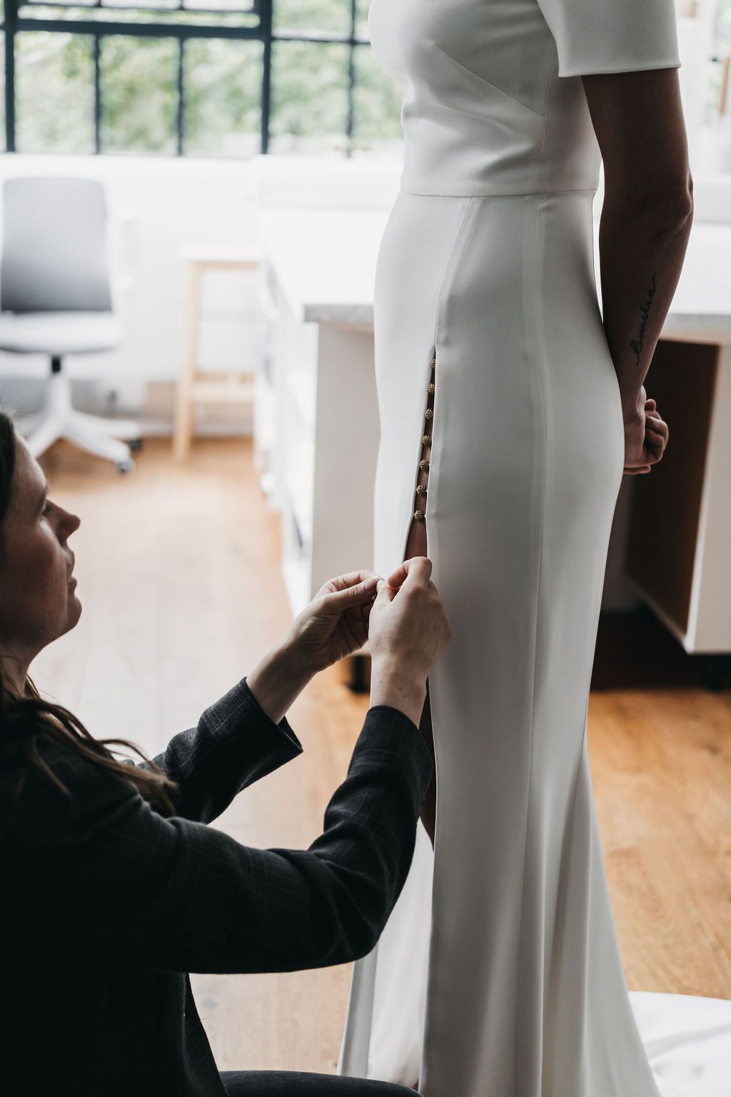 Tailor hemming a dress during a fitting at Sol Quality Cleaners in Weston
